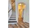 Inviting entryway featuring stairs, wood floors, and access to a half bathroom at 5200 Landmark Dr, St Cloud, FL 34771