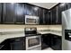 Kitchen with stainless steel appliances, granite countertops, and dark wood cabinets at 5200 Landmark Dr, St Cloud, FL 34771