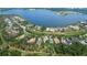 Expansive aerial view of a waterfront property on the lake with surrounding mature trees at 16828 Vinci Way, Montverde, FL 34756
