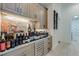Bar area with a built-in wine fridge and decorative shelving for storing a large wine collection at 16828 Vinci Way, Montverde, FL 34756