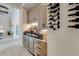 Custom bar with wine refrigerator, display shelving, and ambient lighting for entertaining at 16828 Vinci Way, Montverde, FL 34756