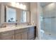Modern bathroom with a granite countertop, dark wood cabinets, and a glass-enclosed shower at 16828 Vinci Way, Montverde, FL 34756