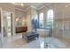 Elegant bathroom featuring tile floors, soaking tub, glass shower, and large window at 16828 Vinci Way, Montverde, FL 34756