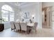 Bright dining room featuring a large arched window, modern chandelier, and neutral decor with tile floors at 16828 Vinci Way, Montverde, FL 34756