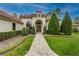Elegant home exterior showcasing a paved walkway and manicured landscaping leading to the arched entryway at 16828 Vinci Way, Montverde, FL 34756