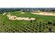 Scenic aerial shot of a golf course with challenging sand traps and mature trees at 16828 Vinci Way, Montverde, FL 34756