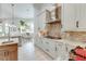 Gourmet kitchen with gas range, mosaic backsplash, marble countertops, and custom cabinetry at 16828 Vinci Way, Montverde, FL 34756