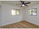 This bedroom includes two windows for natural light, updated baseboards, and a ceiling fan at 220 Lake Gene Dr, Longwood, FL 32779