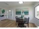 Cozy dining area featuring wood floors, a modern light fixture, and an abundance of natural light through a large window at 220 Lake Gene Dr, Longwood, FL 32779