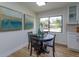 Cozy dining area featuring wood floors, a modern light fixture, and an abundance of natural light through a large window at 220 Lake Gene Dr, Longwood, FL 32779