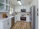 Modern kitchen featuring white cabinetry, quartz countertops, stainless steel appliances and lots of natural light at 220 Lake Gene Dr, Longwood, FL 32779