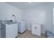 This laundry room features a washer and dryer, white cabinets and neutral tile floors at 220 Lake Gene Dr, Longwood, FL 32779