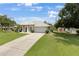 Single story house with a two-car garage and a large yard at 1053 Abadan Dr, Deltona, FL 32725