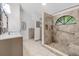 Bright bathroom features tiled walk-in shower, neutral vanity with decorative mirror, and tiled floors at 157 Ambergate Ct, Debary, FL 32713