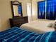 Cozy bedroom featuring comfortable beds, a dresser, and blue curtains for privacy at 3804 Janie Ct, Orlando, FL 32822