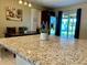 Close up on a granite kitchen island with stainless steel refrigerator and backyard access at 3804 Janie Ct, Orlando, FL 32822