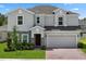 Charming two-story home featuring a well-manicured lawn and a brick-paved driveway leading to a two-car garage at 463 Shadow Gorge Way, Eustis, FL 32736