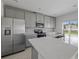 Modern kitchen features stainless steel appliances, gray cabinetry, quartz countertops, and a stylish backsplash at 463 Shadow Gorge Way, Eustis, FL 32736