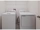 A convenient laundry room features a modern washer and dryer, plus a wire shelf at 463 Shadow Gorge Way, Eustis, FL 32736