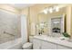 Well-lit bathroom with tub/shower combo, grab bar, and vanity with granite counter at 7573 Laureate Blvd # 1301, Orlando, FL 32827