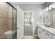 Bright bathroom showcasing a glass shower, granite vanity, and wood look tile flooring at 7573 Laureate Blvd # 1301, Orlando, FL 32827