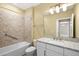 Bathroom with a shower-tub combination, tiled walls, granite vanity, and modern lighting at 7573 Laureate Blvd # 1301, Orlando, FL 32827