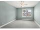 This bedroom has two windows, light teal walls and gray carpet at 7573 Laureate Blvd # 1301, Orlando, FL 32827
