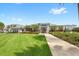 Community clubhouse with manicured lawn, sidewalk, and colorful landscaping at 7573 Laureate Blvd # 1301, Orlando, FL 32827