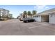 View of garage with open door, parked car, buildings, and palm trees at 7573 Laureate Blvd # 1301, Orlando, FL 32827