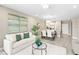 Open-concept living area flows to the kitchen and features neutral tones and stylish décor at 7573 Laureate Blvd # 1301, Orlando, FL 32827