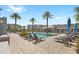 Resort-style pool area with lounge chairs, umbrellas, and tropical landscaping at 7573 Laureate Blvd # 1301, Orlando, FL 32827