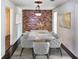 Elegant dining room showcasing a modern light fixture, a decorative accent wall, and a large marble top table at 11543 Se 58Th Ct, Belleview, FL 34420