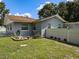 Home exterior featuring well-maintained landscaping, healthy green lawn, and a privacy fence creating a serene outdoor space at 11543 Se 58Th Ct, Belleview, FL 34420