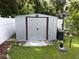 A metal storage shed provides secure outdoor storage, nestled in a green, grassy yard at 11543 Se 58Th Ct, Belleview, FL 34420