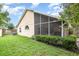 The rear exterior of the home features a screened-in porch overlooking a lush, green lawn at 1611 Sand Key Cir, Oviedo, FL 32765