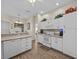 White kitchen with island, stainless steel appliances, and wood-look floors at 7438 Floral W Cir, Lakeland, FL 33810