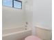 Bathroom with a bathtub, toilet, and window at 10064 Silver Laurel Way, Orlando, FL 32832