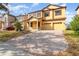 Two-story house with a yellow facade, brick driveway, and landscaping at 10064 Silver Laurel Way, Orlando, FL 32832