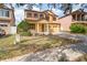 Two-story house with a yellow facade, brick driveway, and landscaping at 10064 Silver Laurel Way, Orlando, FL 32832