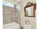 Bathroom with tub and shower featuring tiled walls and framed vanity mirror at 16161 Parkwyn St, Winter Garden, FL 34787