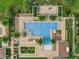 A birds eye view of a geometrically pleasing community pool featuring sun loungers, palm trees, and manicured landscaping at 16161 Parkwyn St, Winter Garden, FL 34787