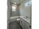 Modern bathroom with white marble-look tile, tub, and stylish vanity at 4445 America St, Orlando, FL 32811