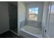 A bathroom featuring a large soaking tub, and a glass-enclosed shower at 4445 America St, Orlando, FL 32811