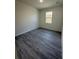 Bedroom features gray wood-look floors, fresh white paint, and bright natural light at 4445 America St, Orlando, FL 32811