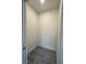 Compact walk-in closet with gray wood-look floors and clean white walls at 4445 America St, Orlando, FL 32811