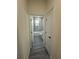 Hallway view leading to a bathroom with white marble-look tile and modern fixtures at 4445 America St, Orlando, FL 32811