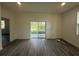 Bright living room with sliding glass doors leading to the backyard, showcasing modern flooring at 4445 America St, Orlando, FL 32811