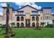 Beautiful Mediterranean style building with arched balconies, lush landscaping, and a vibrant green lawn at 2444 Lobelia Dr, Lake Mary, FL 32746