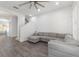 Bright living room with gray sectional sofa, ceiling fan and hardwood floors at 2444 Lobelia Dr, Lake Mary, FL 32746