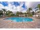 A large in-ground community pool with lounge chairs, palm trees and a tiled pool deck at 12855 Madison Pointe Cir # 106, Orlando, FL 32821